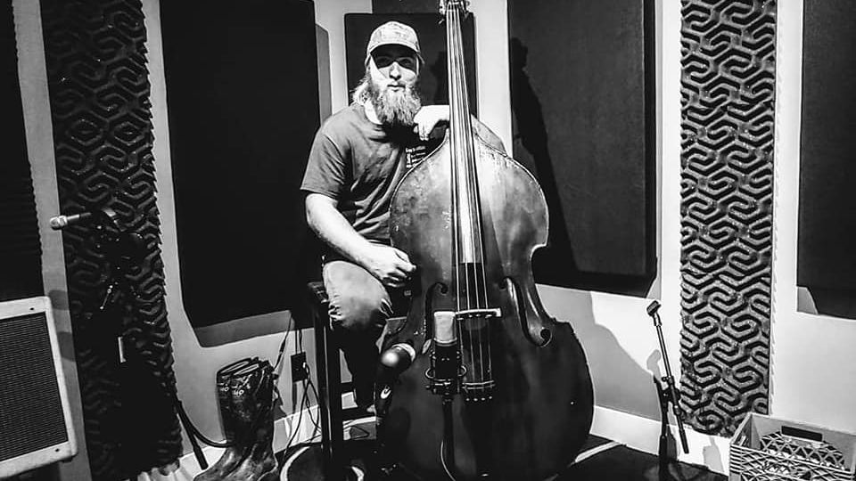 Shane playing upright bass in a studio, black and white